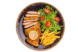 Fried Weiner schnitzel steak, pork breaded fillet meat with french fry and salad isolated on white background photo