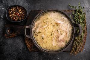 Chicken noodle soup with Vermicelli and meat in a bowl. black background. top view photo