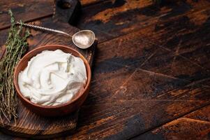 Dip sauce with Fresh Sour cream in a bowl. wooden background. top view photo