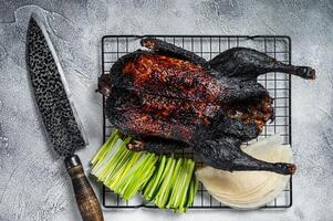 Whole roast Peking duck with herbs, sauce, rice Pancake, Cucumber and onion. White background. Top view photo