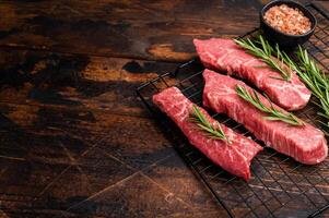 Raw Tri Tip Steak from Black Angus beef meat with rosemary. wooden background. top view photo