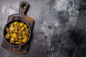 Pickled Jalapeno, Marinated Green Mexican pepper Slices in a skillet. black background. top view photo