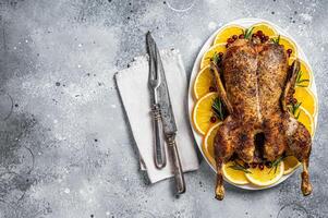 Christmas roast duck with apples and oranges, festive christmas recipe. Gray background. Top view. Copy space photo