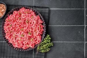 Raw Minced beef and pork meat for a burger patty or meatballs. Black background. Top view. Copy space photo