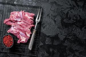 Raw Turkey sliced fillet meat ready for cooking. Black background. Top view. Space for text photo