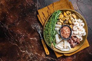 Seafood platter, mix of mussels, clams, squid, octopus, shrimps and prawn. Dark background. Top view. Copy space photo