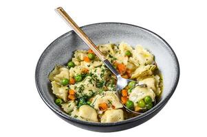 Ravioli Soup dumplings pasta in a bowl with greens. Isolated on white background. Top view. photo