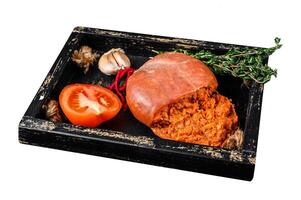 Mallorcan Sobrassada cured pork meat sausage in a wooden tray. Isolated on white background. Top view. photo
