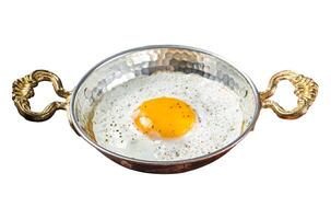 Breakfast with fried egg in a skilet with tomatoes and bacon. Isolated on white background. Top view. photo