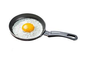 Fried egg in a frying pan with tomatoes and bacon. Black background. Top view. Copy space photo