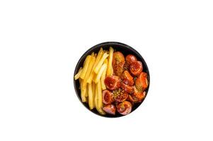 Currywurst street food meal, Curry spice on wursts served French fries in a pan. High quality Isolate, white background. photo