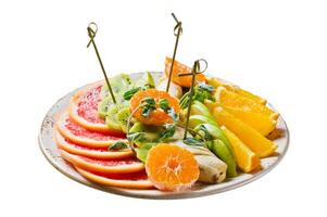 Fruit plate, grapefruit, tangerine, kiwi, orange, banana, Apple. Isolated on white background. photo