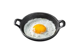 Salted and spiced fried egg in pan with tomatoes, thyme and bacon. Isolated on white background. Top view. photo