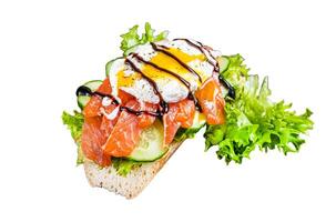 Smoked salmon Sandwich with Benedict egg and avocado on bread. Isolated on white background, top view. photo