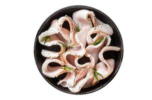 Fresh sliced lard with salt, garlic and pepper in pan with herbs. Isolated on white background. photo