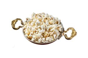Prepared salty popcorn in a skillet and corn kernel. Isolated on white background. Top view. photo
