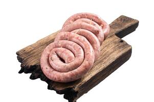Ready for cooking Raw spiral pork meat sausages on a wooden board. Isolated on white background photo