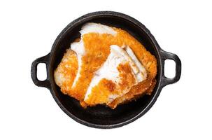 Roasted tilapia fillet in a skillet with breadcrumbs. Isolated, white background. photo