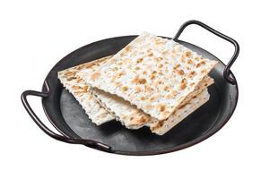 Pieces of matzah in a vintage steel tray. Isolated on white background. Top view. photo