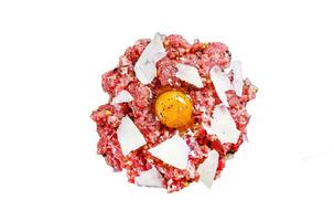 Tartar beef with a quail egg, capers and Parmesan cheese. Isolated on white background, Top view. photo
