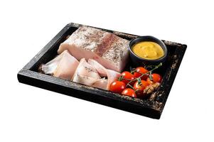 Smoked lard, slices with salt, garlic and pepper in wooden tray with herbs. Isolated on white background. Top view. photo
