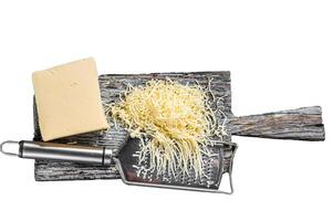 Grated cheese for cooking on a cutting board . Isolated, white background. photo