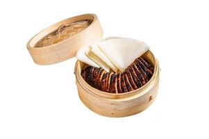 Peking Duck in bamboo steamer served with cucumber, green onion, and wheaten chinese pancakes and sauce Hoysin. Isolated on white background. Top view. photo