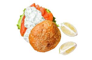 Sandwich with salted fish salmon, avocado, burger bun, mustard sauce and Iceberg salad. Isolated on white background, Top view. photo