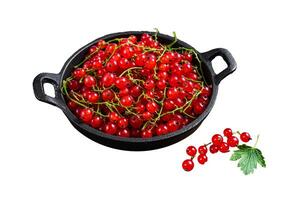 Red currant berries in a pan. Isolated on white background, top view. photo