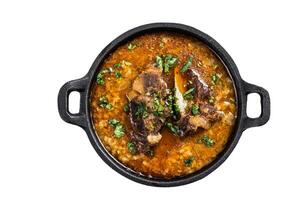 Kharcho soup with beef meat, rice, tomatoes and spices in a pan. Isolated on white background. photo