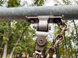 A closeup view of a metal pulley system featuring a chain integrated into playground equipment, showcasing its design and engineering details photo