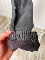 A person is holding a pair of pants in their hand with care photo
