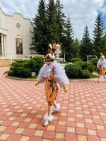 Vibrant and colorful costumed performers delightfully gather in a beautifully scenic garden setting for festivities photo