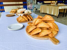 A beautifully crafted wooden cutting board showcases an array of delightful pastries artfully arranged on a lovely table, allowing everyone to easily access and enjoy these treats photo