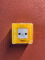 A vibrant yellow emergency call button is prominently displayed on a textured wall, ensuring safe communication during urgent situations photo