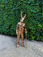 A man in a rabbit costume stands on the sidewalk with a cane photo