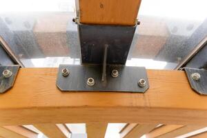 A detailed close up view of a wooden structure featuring metal brackets photo