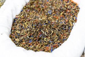 An individual is carefully holding a large pile of tea in their hand photo