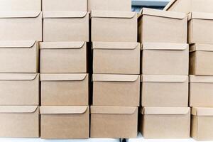 There is a row of cardboard boxes that are stacked atop one another photo