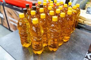 Various bottles of oil are carefully stacked on a table surface photo