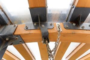 A detailed close up view of a wooden structure that has a chain attached to it photo