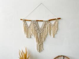 A macrame wall hanging with a wooden stick photo
