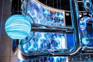 A blue automotive tire is suspended from the ceiling of a building photo