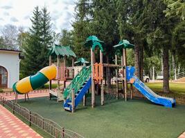 In a vibrant and lively playground setting, theres a brightly colored slide, robust climbing stairs, and a fun tunnel for kids to eagerly explore and enjoy numerous hours of outdoor fun photo