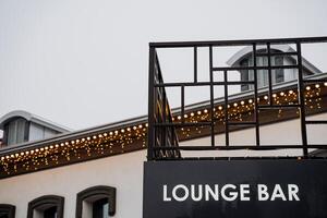 A sign that says lounge bar on the side of a building photo