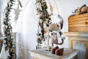 A stuffed animal is sitting on a table in front of a christmas tree photo