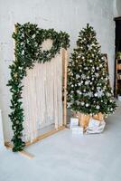 Christmas tree and garland in a white room photo