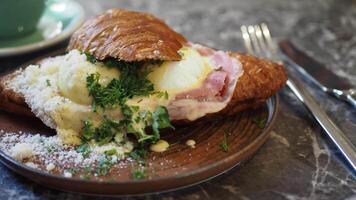 A truly Delicious Croissant Sandwich filled with Ham and topped with a Poached Egg for breakfast video