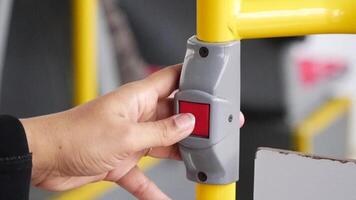 Using a hand to press a button to request a stop for the bus service video
