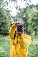 Portrait of man holding a camera over a forest photo